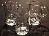 Up for sale are these Svend Jensen Set Of Three Pitchers in excellent condition with no chips or cracks. The Pitchers measure approx. 4 3/4"T by 3"W and hold approx. 12 ounces. They have stickers on the bottom that read Handcrafted in Romania Da