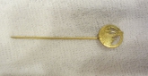 This vintage lapel stick pin from the 70s is a stunning piece that will make a great addition to any jewelry collection. The pin features a round shape and is signed by the renowned brand HUGHNIN. The pin is made of gold-colored material