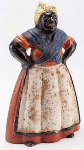 Aunt Jemima Cast Iron Door Stop. USA, circa:1940.  Large cast iron Aunt Jemima figurine, by Hubley.... Approximately 14" tall. Widespread oxidation spots on apron and headscarf. Heavy. 