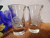Set of 2 One-ounce shot glasses. Clear glass with white heat bonded transfer reading