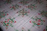 A very cute Pennsylvania Dutch style tablecloth in colors of red and green on a white background. Tulips and a scrolling design . Has a small Dye stain from mfg. The fabric is still crisp and looks to be unused . Measures:  65