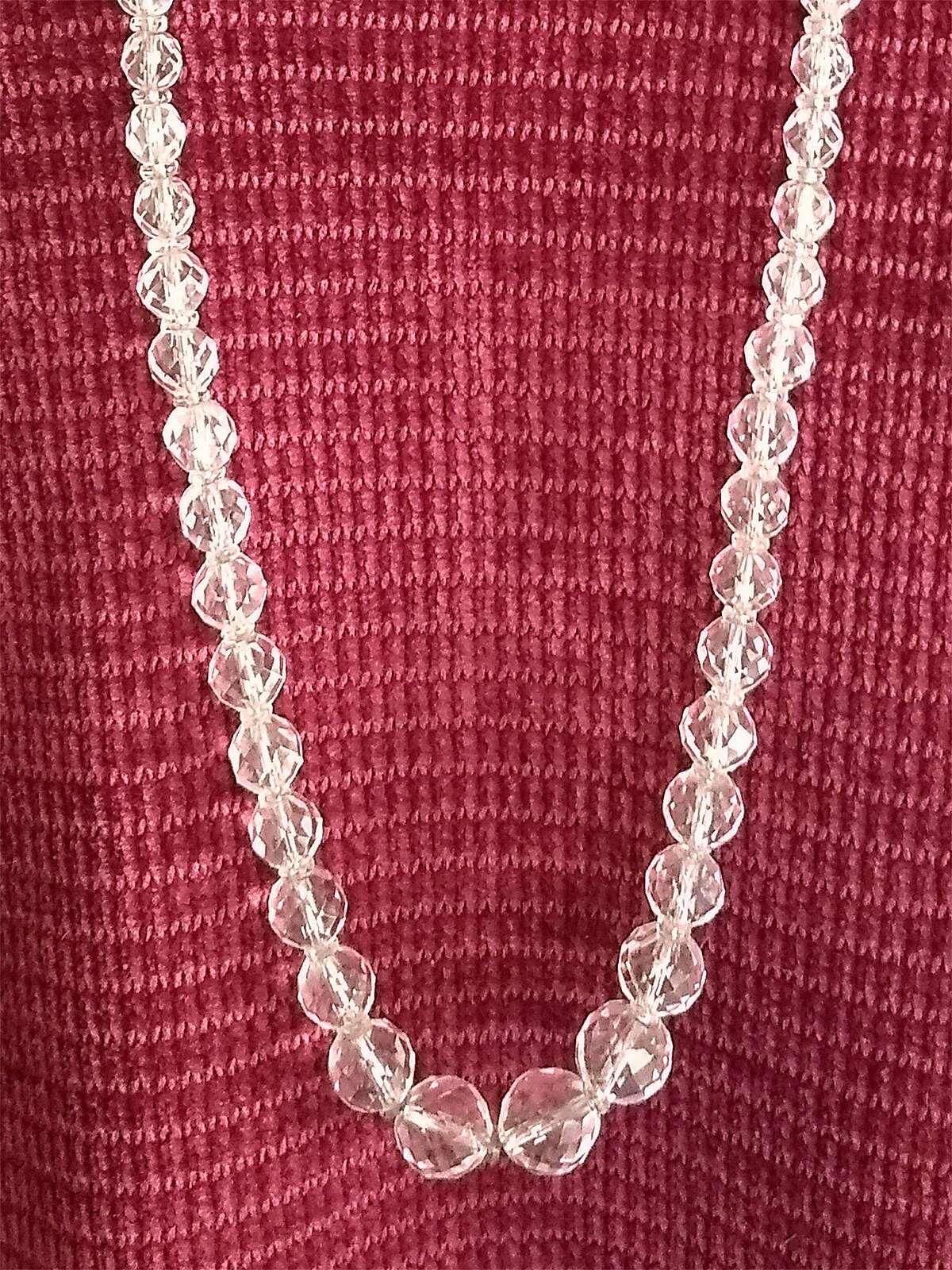 This vintage beaded necklace is made with faceted clear crystal glass beads which graduate evenly from larger in the middle to smaller at the clasp.  The largest bead is 1/2" in diameter.  Length is 28 1/4".  The silver plated clasp reads: "