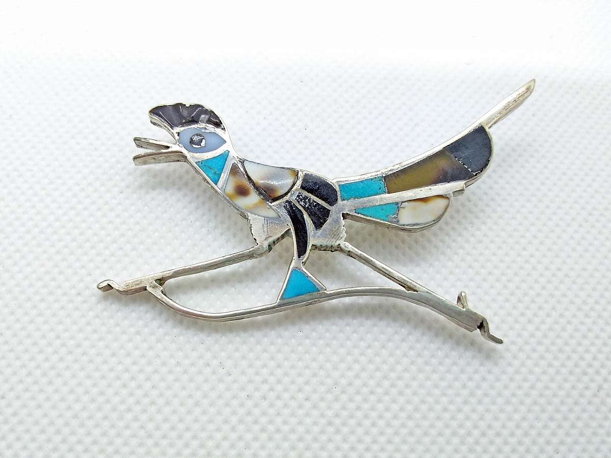 This sterling silver pin or brooch is Zuni, Native American, purchased in the 70's in Arizona. The brooch has multiple inlaid stones of turquoise, mother of pearl, onyx, etc. A stunning hand-made and unique vintage Southwestern piece!