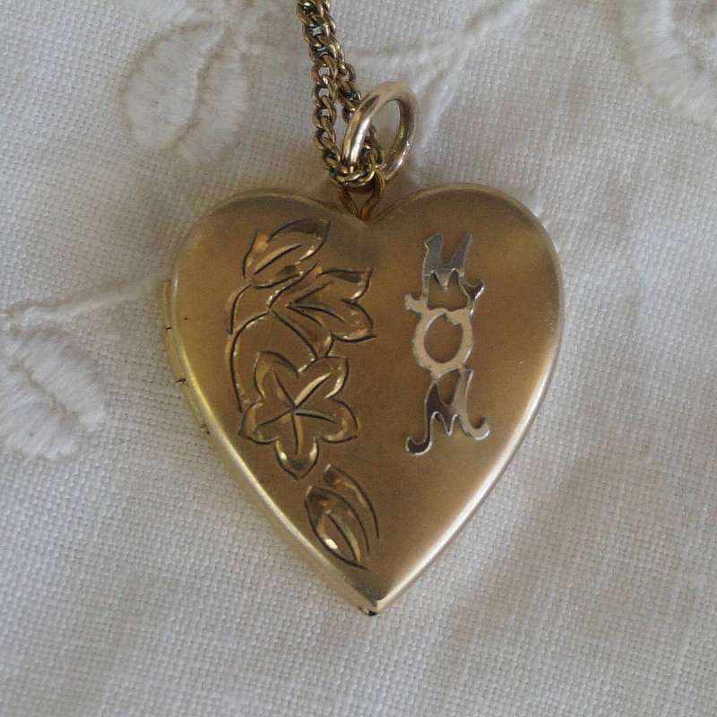 Beautiful vintage gold filled engraved heart "MOM" locket that measures 7/8 inch and is hung on an 18.5 inch  link chain.  The locket is engraved with a flowers and leaves with the word MOM on the top.  It is the perfect classic edition for any