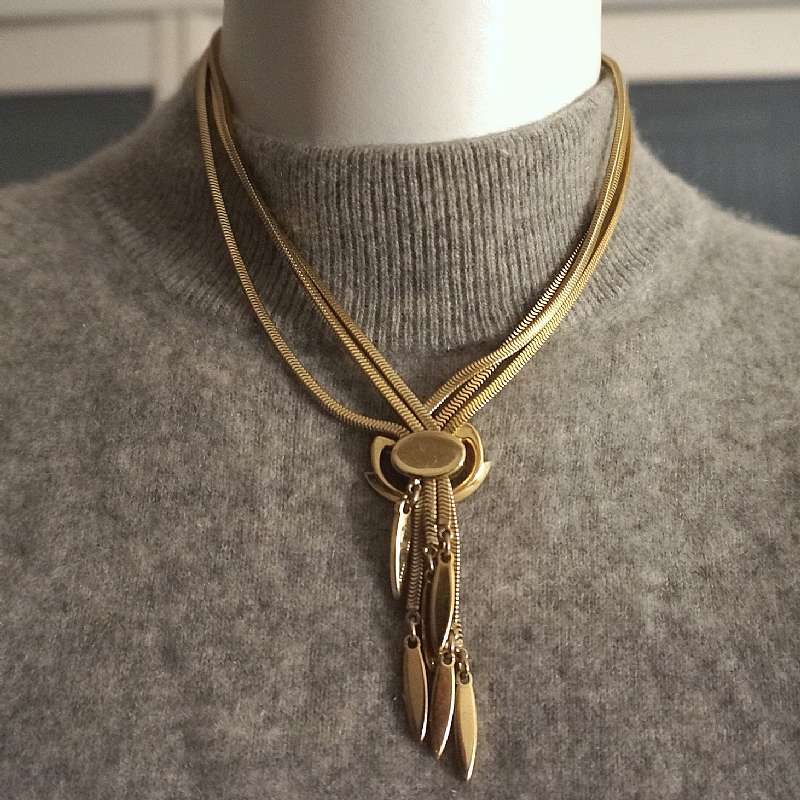 Exceptional vintage serpentine or snake chain fringe or tassel necklace by Monet.  It is gold tone and has three slinkly snakelike chains on each side  that come together with an adjustable slide so that you can shorten or lengthen the tassels.  The neckl