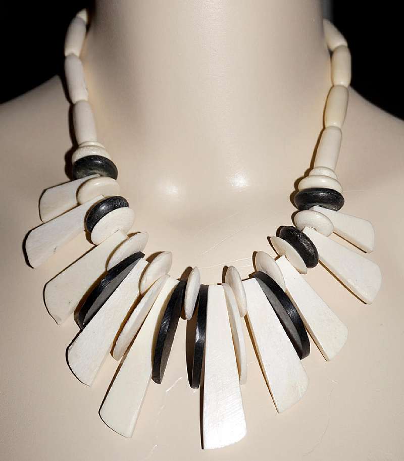 Gorgeous vintage carved ivory colored carved cow bone bead tribal necklace with elk horn contrasting beads done in a fringe style!  The necklace is comprised of 3 different handmade bone beads: round, oval tubes and finger beads.  The elk horn are disk an