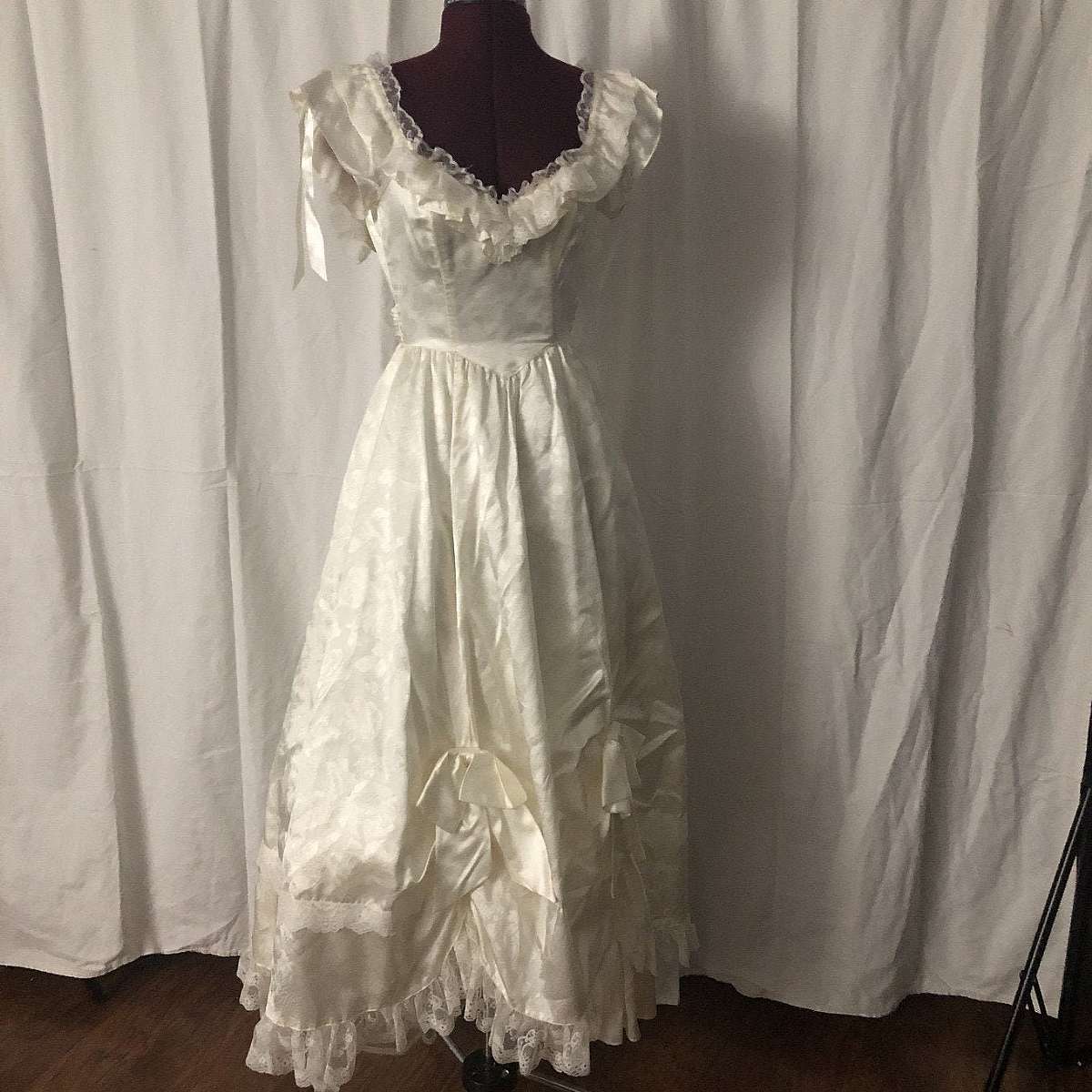 Vintage Gunne Sax cream satin wedding dress bridal gown with bows and raised areas.  This dress is to die for gorgeous and has all kinds of wonderful details and ruffles. It is very girly and looks like an old saloon girl outfit but could be used for a Vi