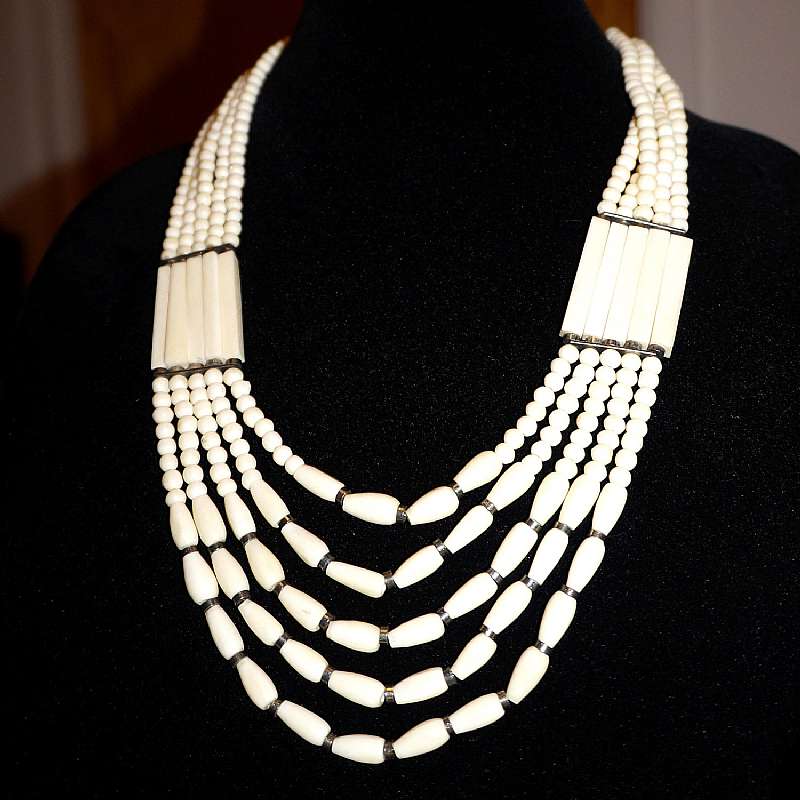 Gorgeous vintage carved ivory colored carved cow bone bead tribal necklace done in 5 amazing strands!  The necklace is comprised of 3 different handmade bone beads: round, tear drop and rectangular tubes.  There are silver tone spacers and a hook clasp.