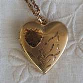 Beautiful antique Victorian engraved heart locket that measures just under an inch and is hung on an 18 inch twisted link chain.  The locket is engraved with a heart and leaves on the top.  It is the perfect classic edition for any bride on her wedding da