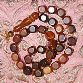 Outstanding rare square shaped bakelite prayer beads in an amber chocolate swirl color.  They are kind of a rounded square beads with a round faceted face on 4 sides and are really much lovelier in hand.  There are 33 beads in total not including the elon