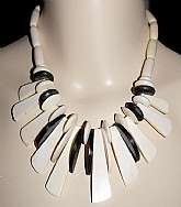 Gorgeous vintage carved ivory colored carved cow bone bead tribal necklace with elk horn contrasting beads done in a fringe style!  The necklace is comprised of 3 different handmade bone beads: round, oval tubes and finger beads.  The elk horn are disk an