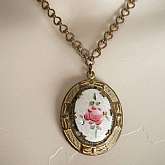 Gorgeous Art Nouveau vintage gilt brass guilloche enamel locket necklace. It had a lovely hand painted rose motif on guilloche enamel base with patterned bronze tone metal and bow accents. Measures 1 5/8 inches on the pendant and 16 inches on the unique p