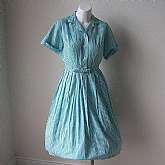 Gorgeous vintage 50s rockabilly pleated shirtwaist day dress in light aqua gingham check fabric. The dress is made in cotton with cuffed sleeves, all around full pleats and button down front. It has fabulous peekaboo embroidery on the bodice front and bac