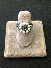 Gorgeous vintage sterling silver cultured pearl and sapphire filigree ring. The setting is done like a lovely flower with multiple sapphire stones at the center. The ring is a size 6 and is in excellent condition.