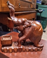 Wood hand-carved elephant.  The head opens with a hinge to reveal a secret storage compartment.
