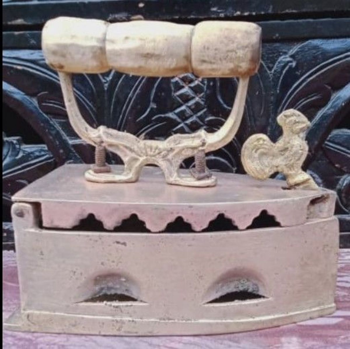 A rooster iron is a traditional iron made of cast iron heated with charcoal or embers in a combustion chamber.It is called "rooster iron" because the top cover usually features a brass or iron ornament of a rooster's head.