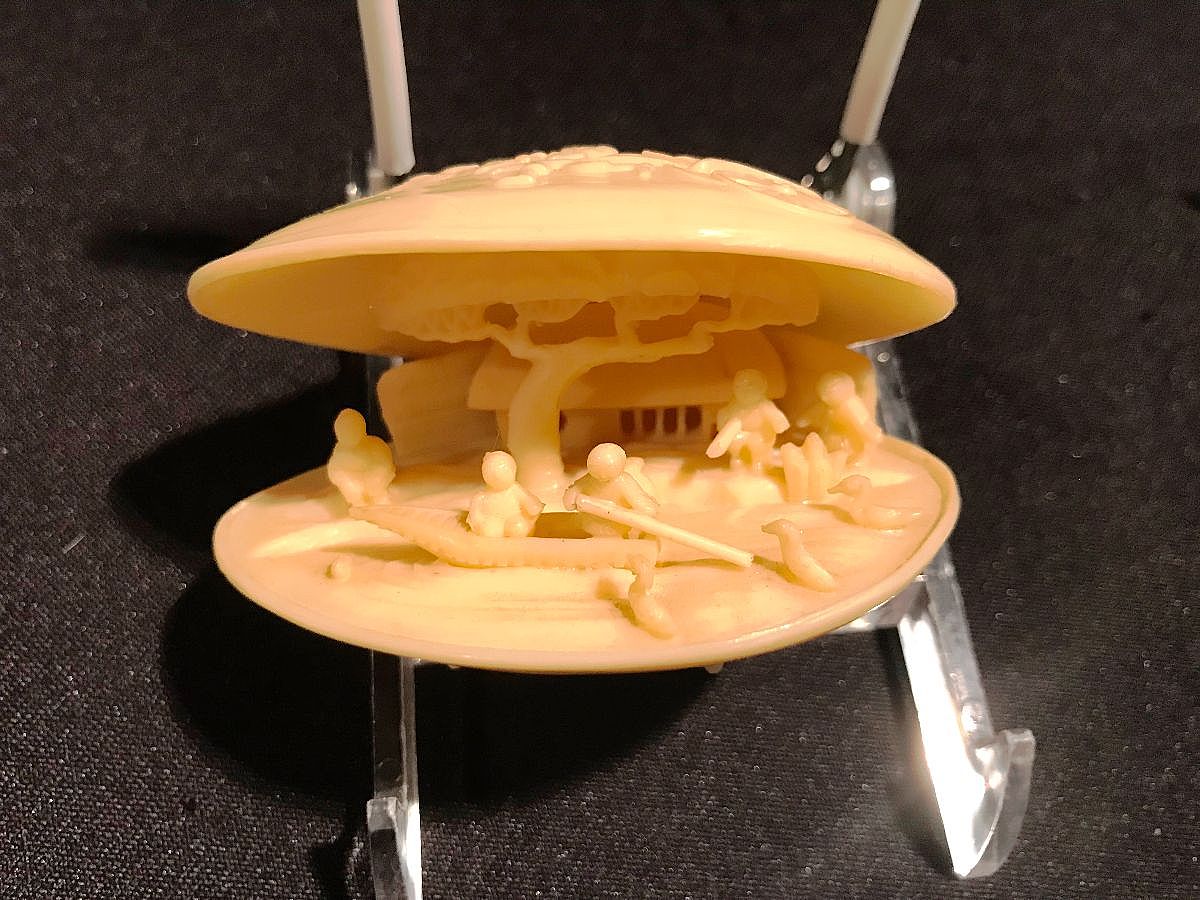 Vintage ivory-toned celluloid clamshell art pieces were popular collectibles, especially as Japanese dioramas featuring intricate hand-carved scenes within the shell casing during the 1930s to 1950s.