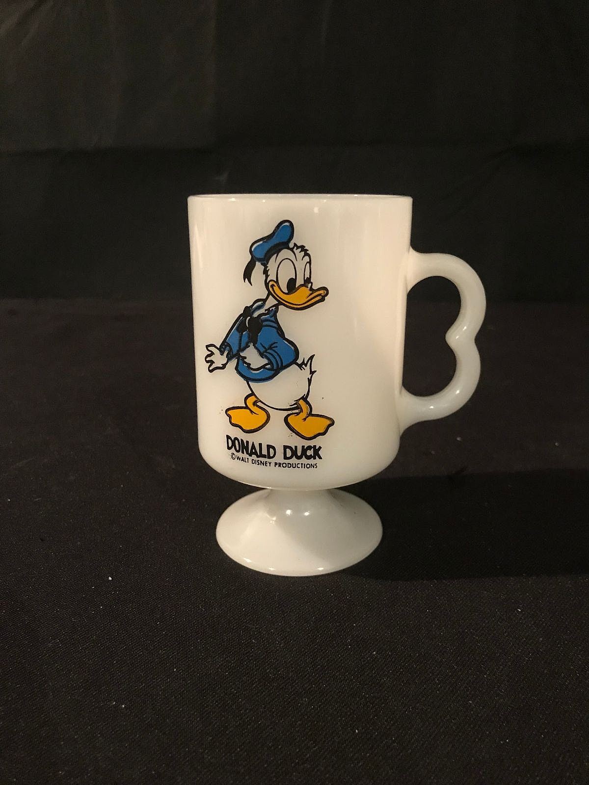 Donald Duck is an anthropomorphic white duck with a yellow-orange bill, legs, and feet. He typically wears a sailor shirt and cap with a bow tie.