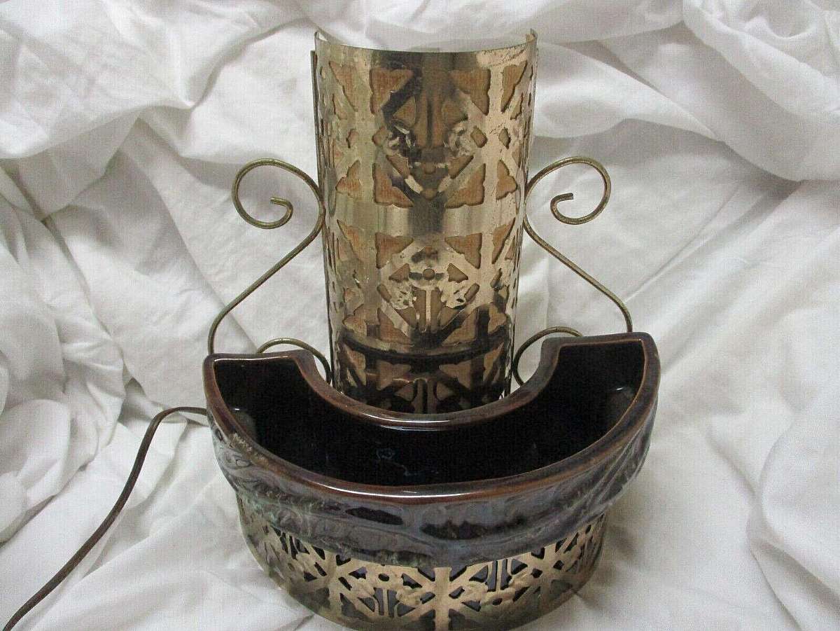 In very good condition but will still have monor scratches on item and look aged. A textured brown pottery planter with green accents and gold tone metal frame. There are age spots on the gold tone metal but it adds to the vintage charm. I think it would