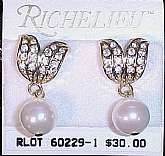 These elegant, mint condition, vintage earrings were designed by Richelieu.  They are pierced and 5/8" wide x 1 1/4" in length.  Featured at the top are two gold toned leaves with pave crystals.  Below dangles a simulated round pearl.  Bought bu