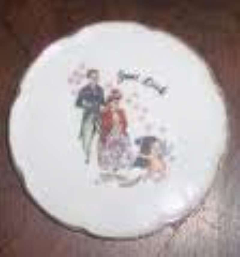 This is a 4 inch collector plate made in Japan. It says Good Luck and shows an in love Victorian Couple getting their photo taken by cupid. Gold rimmed with a little wear on the rim. No chips or cracks.  Great Valentines gift.  Insured.