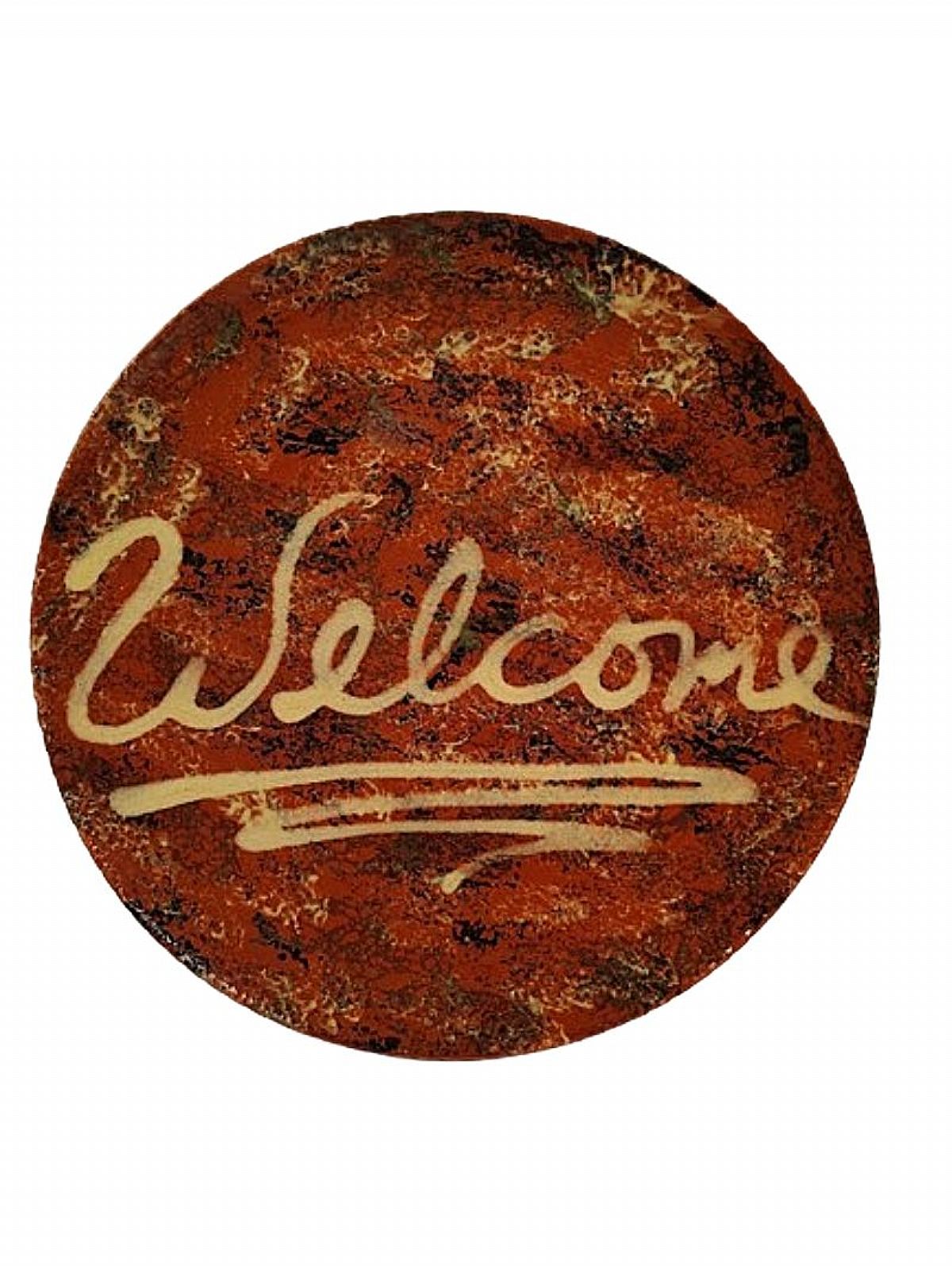A nice piece of rustic redware, this 9-inch plate was hand made in 1985 by Gris Pottery in Dundee, Illinois. In the tradition of antique redware pottery, the surface is sponged in black and yellow and has the word "Welcome" exuberantly handwritten in 