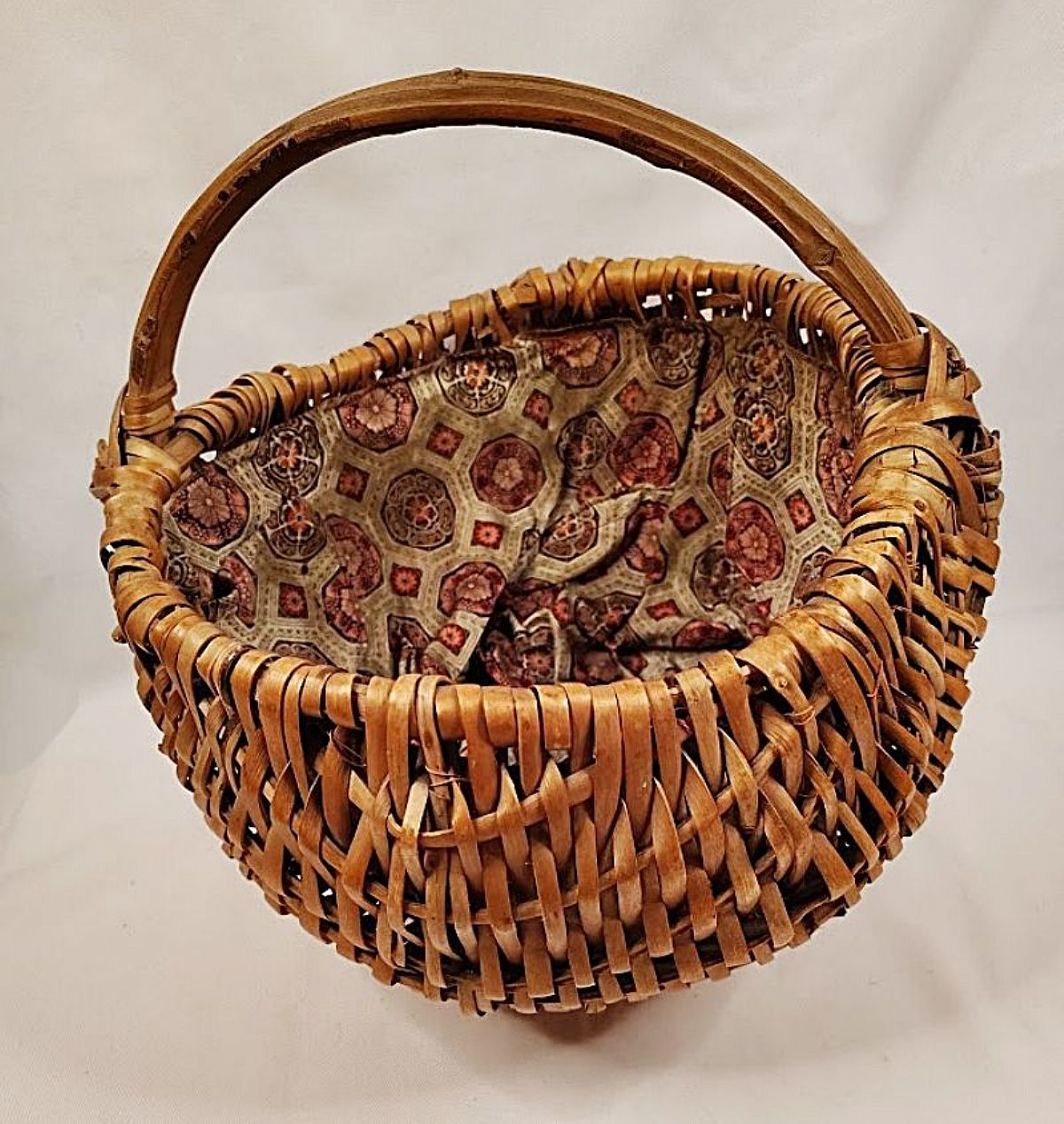 This authentically Depression-era large willow basket was hand woven by a thrifty woman in the 1920s. Found in the Appalachian state of Kentucky, the basket has a sturdy, skinned willow rod handle, 