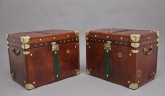 These are a fabulous pair of early 20th Century leather bound ex army trunks with brass straps and corners, copper studs and brass carrying handles on the sides, the trunks opening to reveal a nice dark blue lined interior.