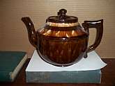 Graceful and balanced 6 cup plus redware teapot from the turn of the Victorian century. Fully glazed, inside and out, with no visible damage: however, note the two tiny chips on the lid's interior rim. They do not rest within the pot, and are not visible