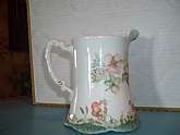 Beautiful  and truly unique Homer Laughlin milk pitcher with its original floral design called "Hudson". Further embellished by a talented hand with a lovely little skirted garden including a bird, strawberries and other florals.  No chips, crac