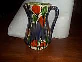 Beautiful MCM artists' studio drip glaze/splash glaze pottery pitcher, Measures 8.5 x 4.5 plus the handle. When it is viewed one way, it appears as if it is a garden of flowers behind a grille of fine lines; viewed another way, it appears to be a brillian