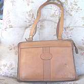 This is a woman's tailored all leather handbag from the 1950's. Very well made, fully stitched, with two zippered pockets. All Metal Zippers with original leather tabs. Handles are smooth leather lined. Larger interior is cloth divided between zippers, an