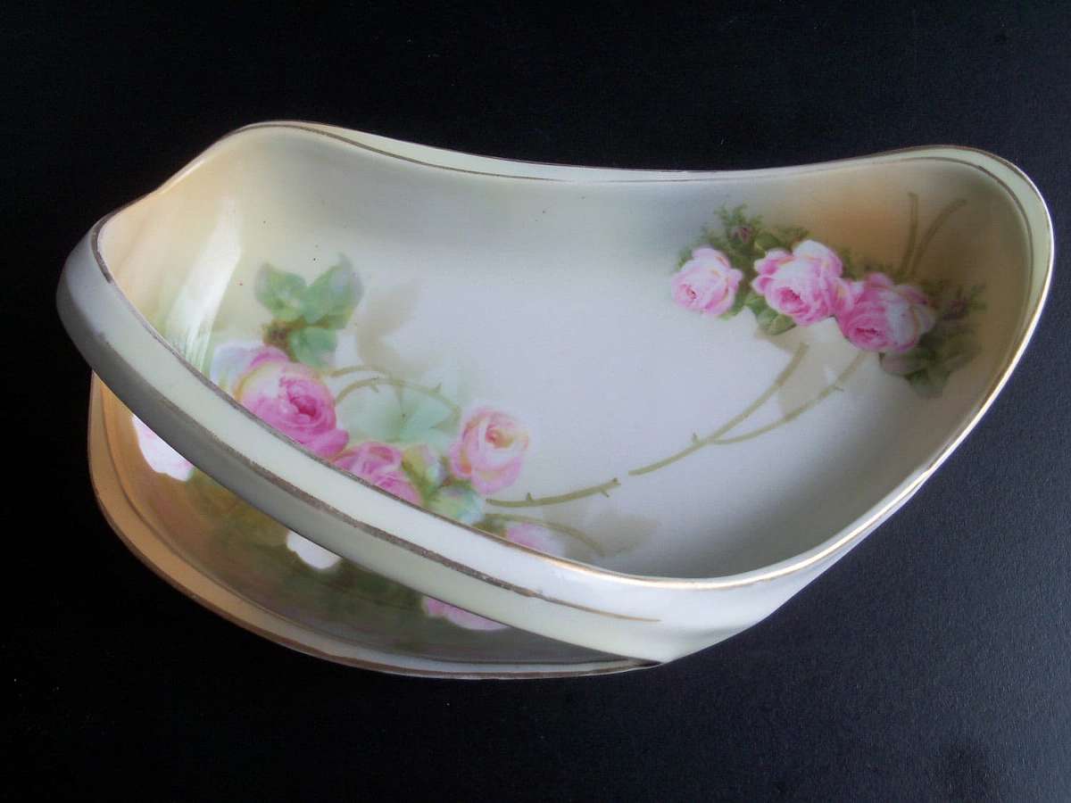 Up for sale is this  Schlegelmilch Porcelain Germany Handled Rose Design Bowl in great condition with no chips or cracks. Minor gold wear. It measures approx. 8"L by 4 3/4"W at its widest point. This mark was used between 1912-1945. Shipping Ex