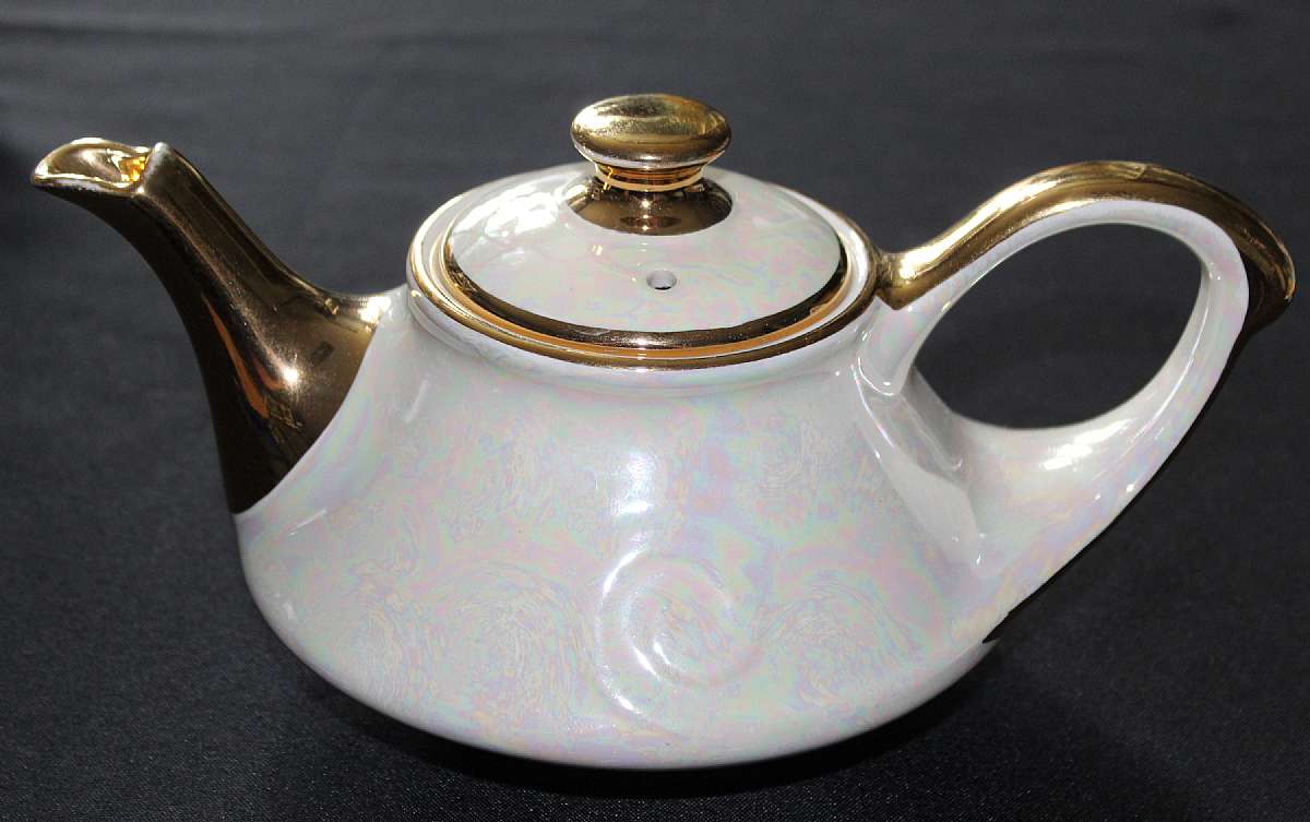 Up for sale is this vintage Pearl China Company Teapot Iridescent 22kt Gold Hand Decorated Tea Pot in excellent condition with no chips or cracks. Measures about 10 1/2 inches from spout to end of handle and 4" tall without the lid.Shipping Excludes