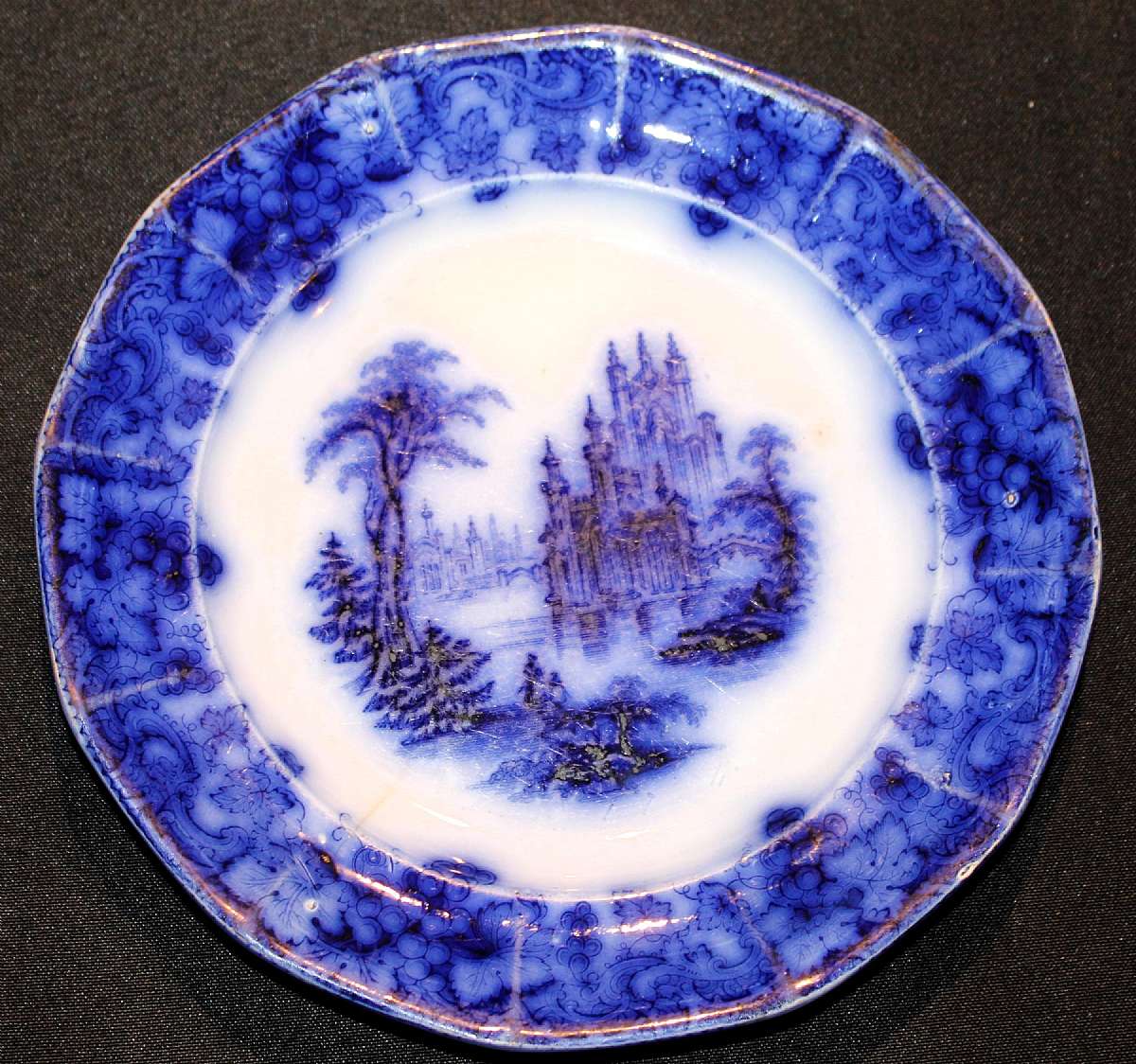 Up for sale is this Antique Staffordshire Gothic Flow Blue Ironstone Plate. It measures approx. 8 1/4"W. There is a hairline crack and a nick on the rim pictured.Shipping Excludes: Alaska/Hawaii, US Protectorates, APO/FPO, PO Box Shipping Provided