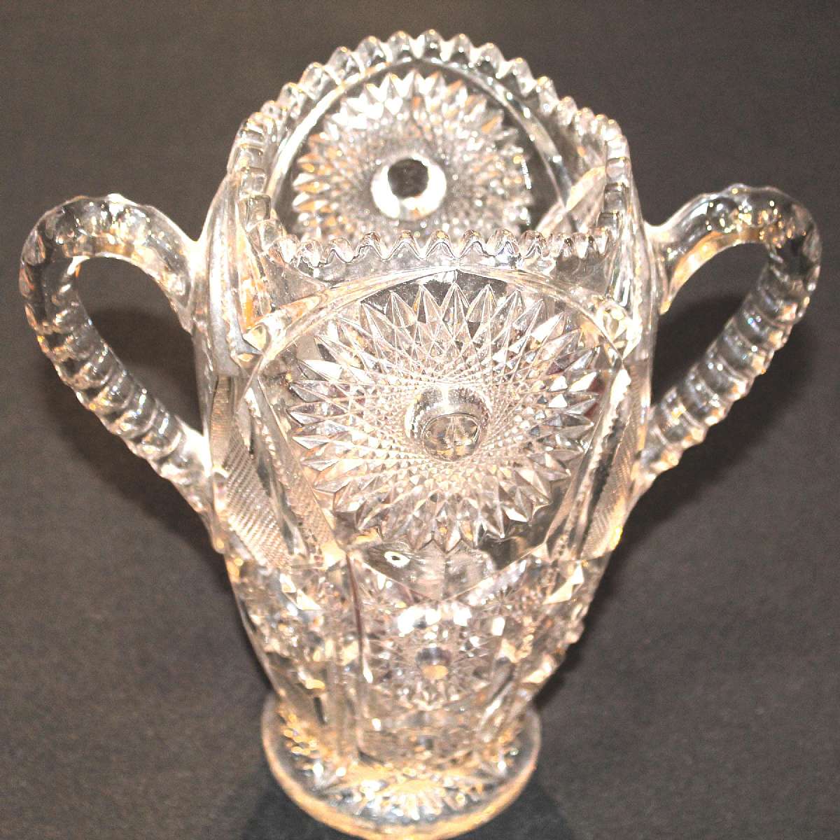 Up for sale is this Vintage Glass Saw Tooth Rim Heavily Decorated Handled Vase in excellent condition with no chips or cracks. Measures approx. 10 3/4"T by 4 3/4"W at the top. Stunning Piece. Shipping Excludes: Alaska/Hawaii, US Protectorates,