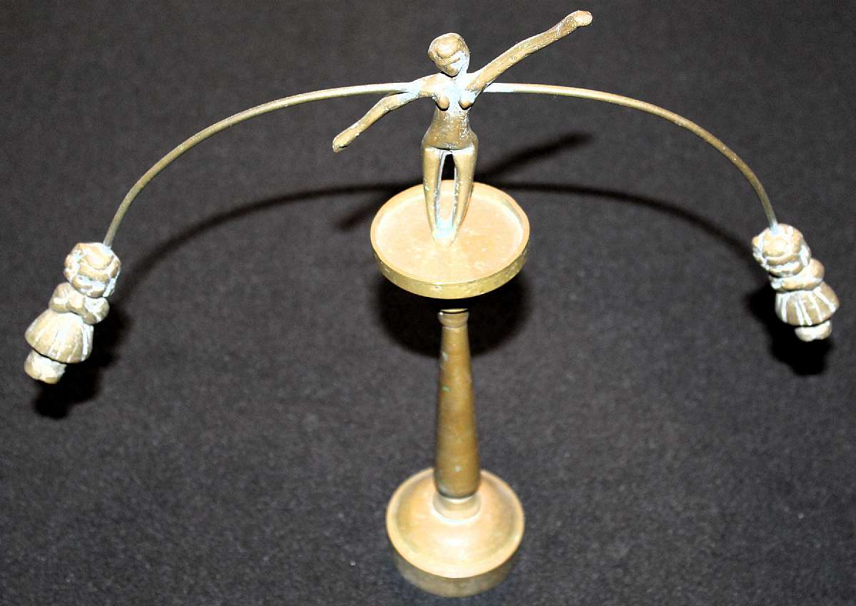 Up for sale is this really cool Vintage Solid Brass Woman High Wire Balancing Act Holding Pole With Kids on a stand. When you push on her she will swing precariously back and forth but will not fall off. The stand measures approx. 7 1/2"T and the lady sta